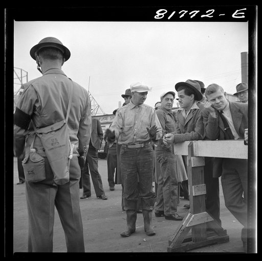 Untitled photo, possibly related to: Army sentries standing guard at transport dock one day after the Japanese attack on Pearl Harbor. San Francisco, California