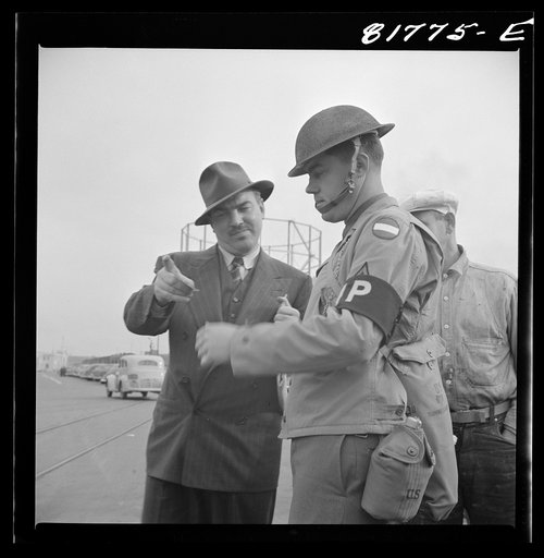 Army sentries standing guard at transport dock one day after the Japanese attack on Pearl Harbor. San Francisco, California
