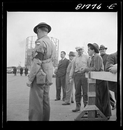 Untitled photo, possibly related to: Army sentries standing guard at transport dock one day after the Japanese attack on Pearl Harbor. San Francisco, California