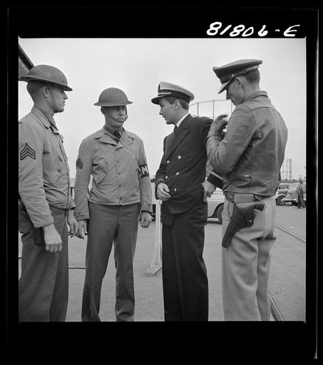 Officer of transport searching for his identification. Transport dock, San Francisco, California