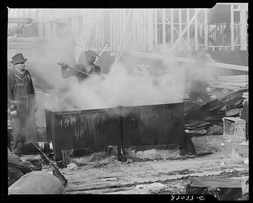 Melting tar for roofing on emergency defense office construction job. Washington, D.C.