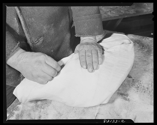 Sewing bag around meat for sanitary food storage. Calvert County, Maryland