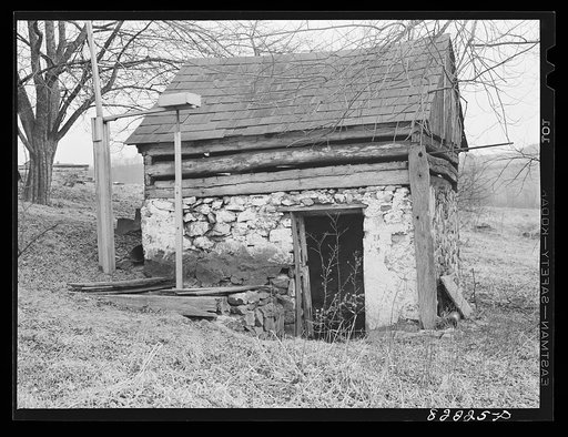 Bucks County, Pennsylvania. Water piped from stream enters this springhouse and operates waterwheel which supplies power for pump at top of hill