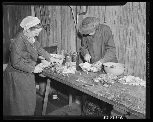 Honey Brook, Pennsylvania (vicinity). Amish man and wife cutting up beef for canning
