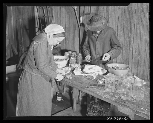 Untitled photo, possibly related to: Honey Brook, Pennsylvania (vicinity). Amish man and wife cutting up beef for canning
