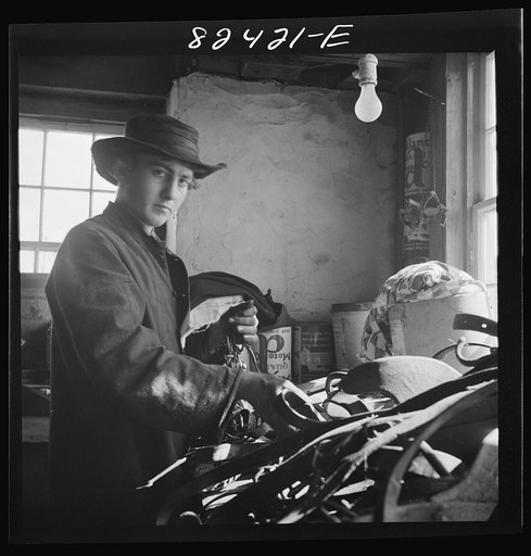 Honey Brook, Pennsylvania (vicinity). Amish farmland mending harness on the Zook farm. Electric light overhead has been disconnected for religious reasons