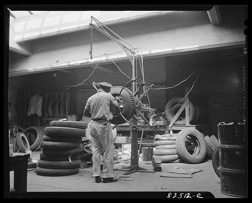 Washington, D.C. Washington tire shop. Spreading a tire to inspect its walls to decide whether it can be retreaded