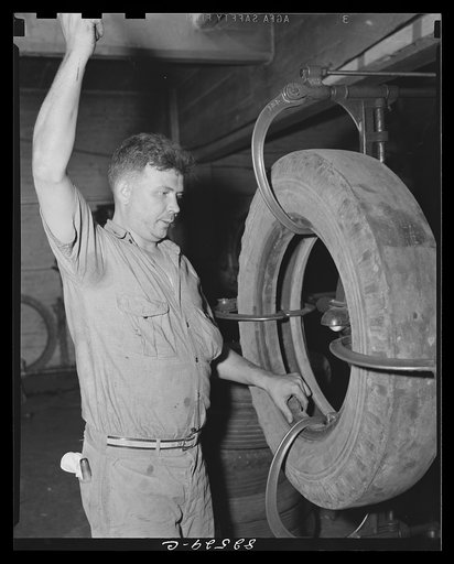 Washington, D.C. Washington tire store. Bending out walls of a tire to inspect it before retreading