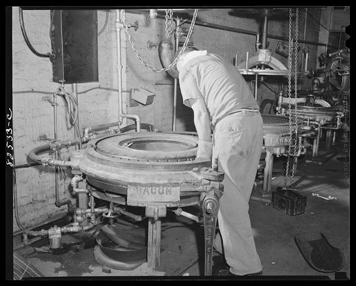 Washington, D.C. Washington tire store. Settling tire in vulcanizing mould where it will "cook" for three hours to "cure" the recap onto the old tire