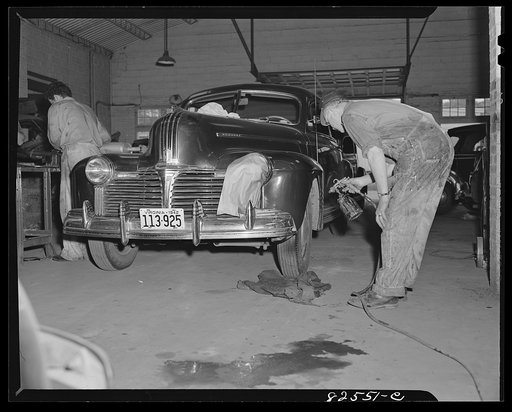 Arlington, Virginia. Spray-painting a fender after straightening