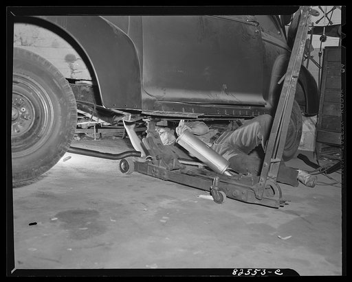 Arlington, Virginia. Auto refinishing plant. Installing a new muffler