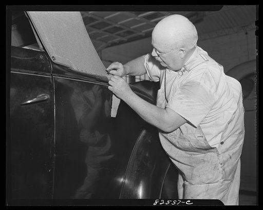 Untitled photo, possibly related to: Arlington, Virginia. Auto refinishing plant. Tacking down new top on an old car