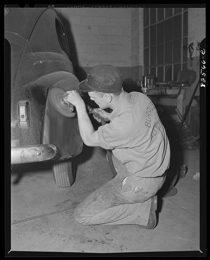 Untitled photo, possibly related to: Arlington, Virginia. Auto refinishing plant. Beating dents out of a car body