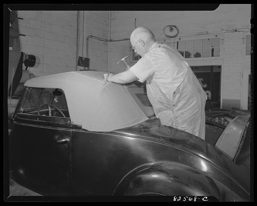 Arlington, Virginia. Auto refinishing plant. Tacking down new roadster top