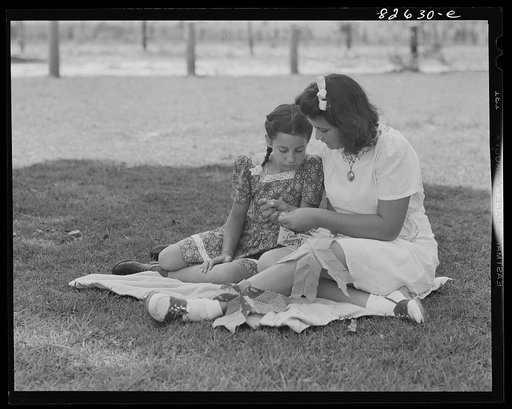 Untitled photo, possibly related to: Escambia Farms, Florida. Elena McLelland giving her sister, Kitty, a sewing lesson on the family lawn on a Sunday