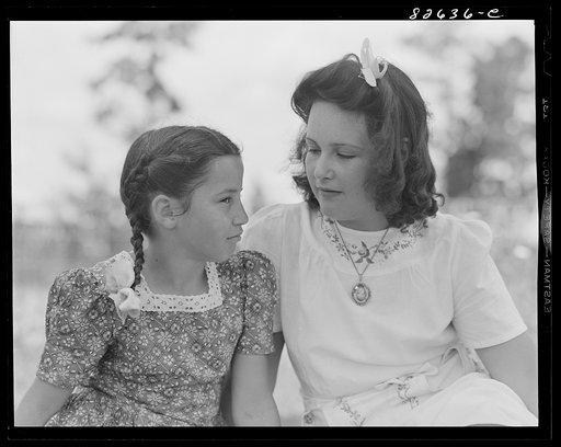 Untitled photo, possibly related to: Escambia Farms, Florida. Elena McLelland giving her sister, Kitty, a sewing lesson on the family lawn on a Sunday