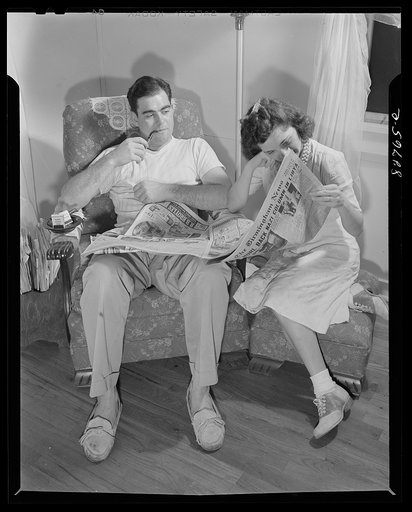 Untitled photo, possibly related to: Childersburg, Alabama. Cousa Court defense housing project. Mr. Smith and his wife, both defense workers in the Dupont powder plant, follow the course of the war through the local paper