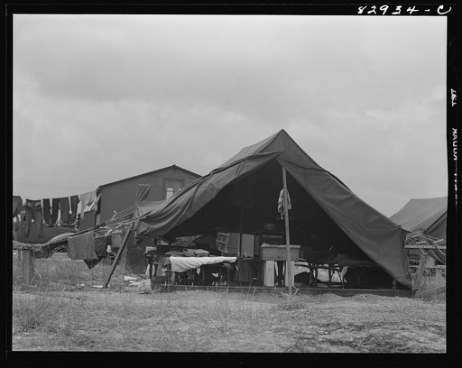 Untitled photo, possibly related to: Bridgeton, New Jersey. FSA (Farm Security Administration) agricultural workers' camp. Migrants filling ticks with straw to serve as mattresses