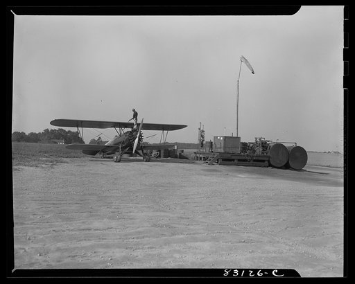 Untitled photo, possibly related to: Bridgeton, New Jersey. Seabrook Farm. Loading gasoline into a dusting plane. Dust or insecticide is spread by low flying planes onto crops to control various insect pests