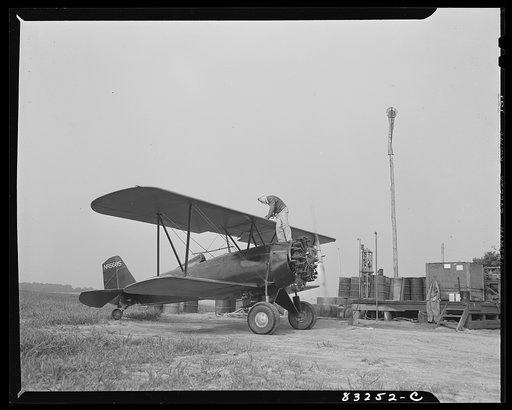 Bridgeton, New Jersey. Seabrook Farm. Delivering gasoline to plane, at dawn, for dusting fields. Dust or insecticide is spread by low flying planes onto crops to control various insect pests