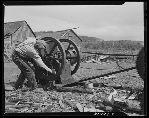 Fort Kent. Maine (vicinity). Edward [i.e. Oneil] Daigle uses this kerosene-burning engine to saw the winter supply of wood