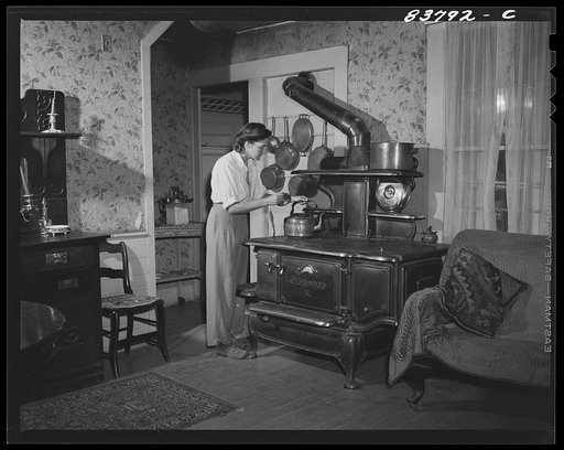 Hartford, Connecticut (vicinity). Mrs. Komorosky in her living room. Stove is for heat in winter, Russian style!