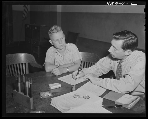 Richwood, West Virginia. Representative of the FSA (Farm Security Administration) signing up Charles Lindbherg Rhone for work in the harvest in upper New York state
