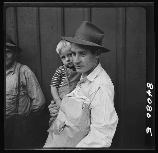Richwood, West Virginia. Father and son boarding train for Batavia, New York, where they will work in the harvest