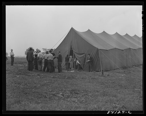 Batavia, New York. Elba FSA (Farm Security Administration) farm labor camp. Group of migrants from West Virginia gathered outside recreation tent discussing the problem of getting something to eat. They have just arrived by train