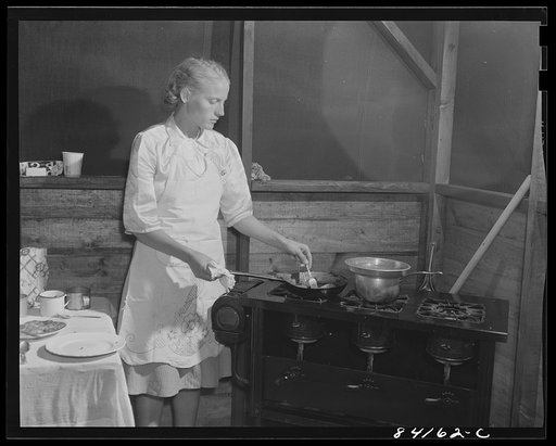 Batavia, New York. Elba FSA (Farm Security Administration) farm labor camp. Hazel Friend getting dinner on a kerosene stove