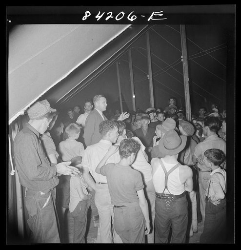 Batavia, New York. Elba FSA (Farm Security Administration) farm labor camp. Ray Mork, FSA official, addressing West Virginia migrants on the night of their arrival
