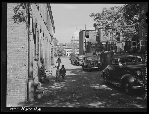 Temple Court off D Street and Delaware Avenue, S.W. Washington, D.C. Negro slum area with Capitol in background