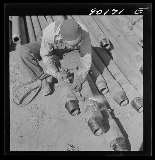 Floyd Swick, welder from Newton, Kansas worked in oil fields about ten years; cutting tool joints off a drill pipe in Goodrich field of Continental oil company. Valley Center oil field near Wichita, Kansas