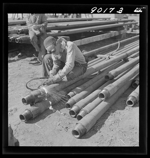 Floyd Swick, welder from Newton, Kansas worked in oil fields about ten years; cutting tool joints off a drill pipe in Goodrich field of Continental oil company. Valley Center oil field near Wichita, Kansas