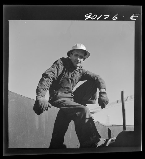 Jess Richmond, pipe wrecker from Blackwell, Oklahoma by oil well being drilled in Goodrich field of the Continental oil company. Valley Center oil field near Wichita, Kansas