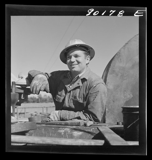 Elmer Womack, derrick man from Fairfax, Oklahoma overhauling mud hog where oil well is being drilled in Goodrich field of Continental oil company. Valley Center oil field near Wichita, Kansas. He has been working in Kansas fields about six years, used to be a pumper and worked in oil fields since he