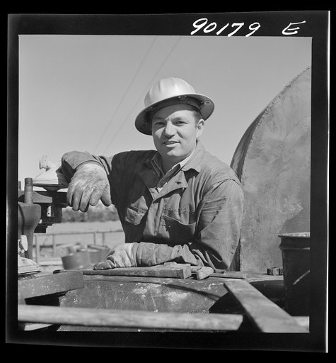 Untitled photo, possibly related to: Elmer Womack, derrick man from Fairfax, Oklahoma overhauling mud hog where oil well is being drilled in Goodrich field of Continental oil company. Valley Center oil field near Wichita, Kansas. He has been working in Kansas fields about six years, used to be a pum