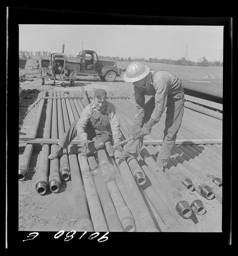 Untitled photo, possibly related to: Floyd Swick, welder from Newton, Kansas worked in oil fields about ten years; cutting tool joints off a drill pipe in Goodrich field of Continental oil company. Valley Center oil field near Wichita, Kansas