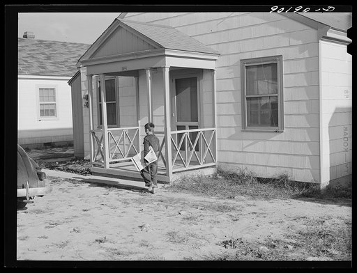 Boy delivering newspapers to defense workers homes in Sunset Village. FSA (Farm Security Administration) project. Radford, Virginia
