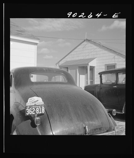 "Help Radford Blow The Hell Out Of Hitler" sign on the back of a defense worker's car in front of his home in Sunset Village, FSA (Farm Security Administration) project. Radford, Virginia