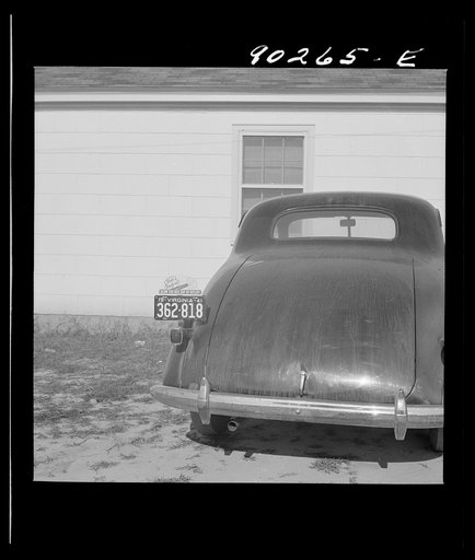 Untitled photo, possibly related to: "Help Radford Blow The Hell Out Of Hitler" sign on the back of a defense worker's car in front of his home in Sunset Village, FSA (Farm Security Administration) project. Radford, Virginia