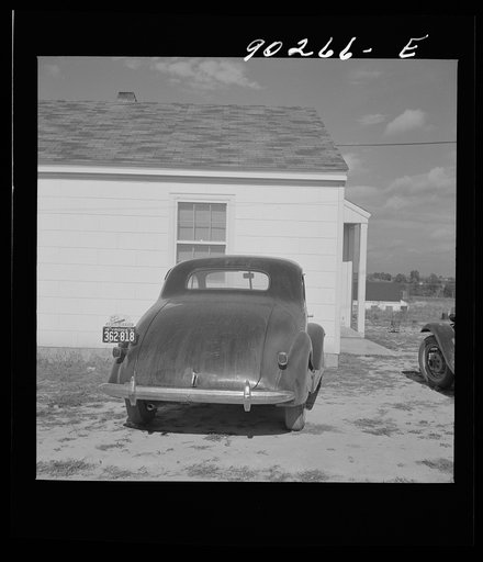 Untitled photo, possibly related to: "Help Radford Blow The Hell Out Of Hitler" sign on the back of a defense worker's car in front of his home in Sunset Village, FSA (Farm Security Administration) project. Radford, Virginia