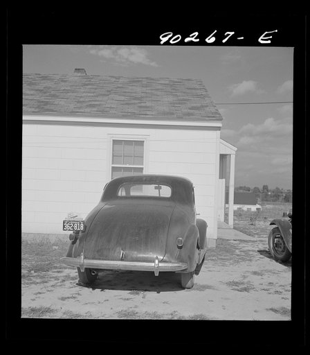 Untitled photo, possibly related to: "Help Radford Blow The Hell Out Of Hitler" sign on the back of a defense worker's car in front of his home in Sunset Village, FSA (Farm Security Administration) project. Radford, Virginia