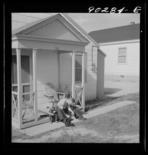 Untitled photo, possibly related to: Radford, Virginia. Sunset Village, FSA housing project. Fred B. Williams from Savannah, Georgia, and his son "Buddy" cleaning the car distributer on the porch of his home. 803 9th Street