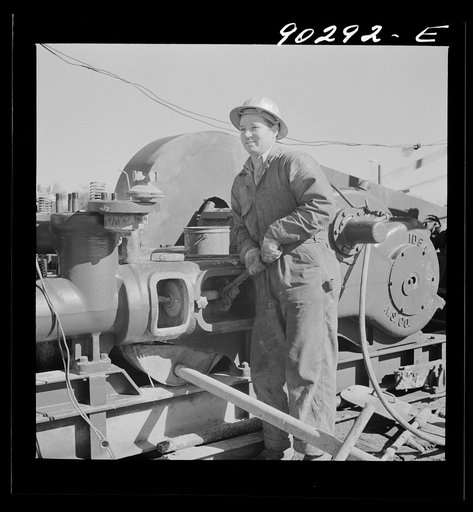 Elmer Womack, derrick man from Fairfax, Oklahoma overhauling mud hog where oil well is being drilled in Goodrich field of Continental oil company. Valley Center oil field near Wichita, Kanasas. He had been working in Kansas fields about six years, used to be a pumper and workerd in oil fields since 