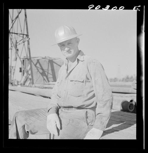 T.J. Schenermann, driller from Oklahoma, worked in Kansas oil fields about fifteen years; by oil well being drilled in Goodrich field of Continental oil field near Wichita, Kansas