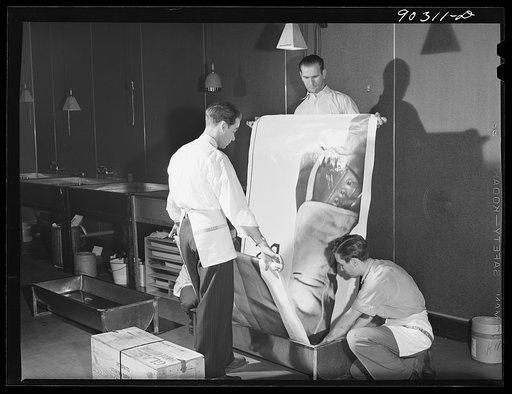 Washington, D.C. Preparing the defense bond sales photomural to be installed in the Grand Central terminal, New York, in the photographic laboratory of the FSA (Farm Security Administration). Reenacment of development of a print strip
