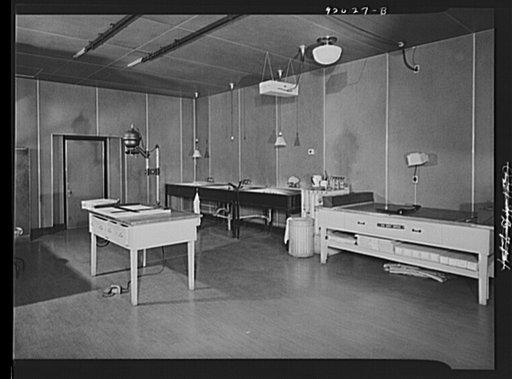 U.S. FSA (Farm Security Administration), later U.S. Office of War Information, photograph laboratory in the Auditor's Building. Washington, D.C. Enlarging room, showing a Leitz miniature enlarger and developing sinks