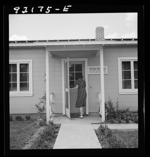 Untitled photo, possibly related to: Tulare County, Farmersville, California. Farm Security Administration (FSA) camp for migratory agricultural workers. Entering clinic of Agricultural Workers' Health and Medical Association (FSA) for nurse's help with sick baby. Older woman says, "I'm just a neigh