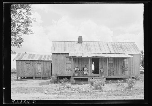 Untitled photo, possibly related to: House of Negro tenant family. This is a larger house than usual box type. Has several rooms, unscreened, but well kept. Part of the family is sitting on the porch resting--Saturday afternoon. The oldest son on the mule is on his way to visit a neighbor. Pittsboro